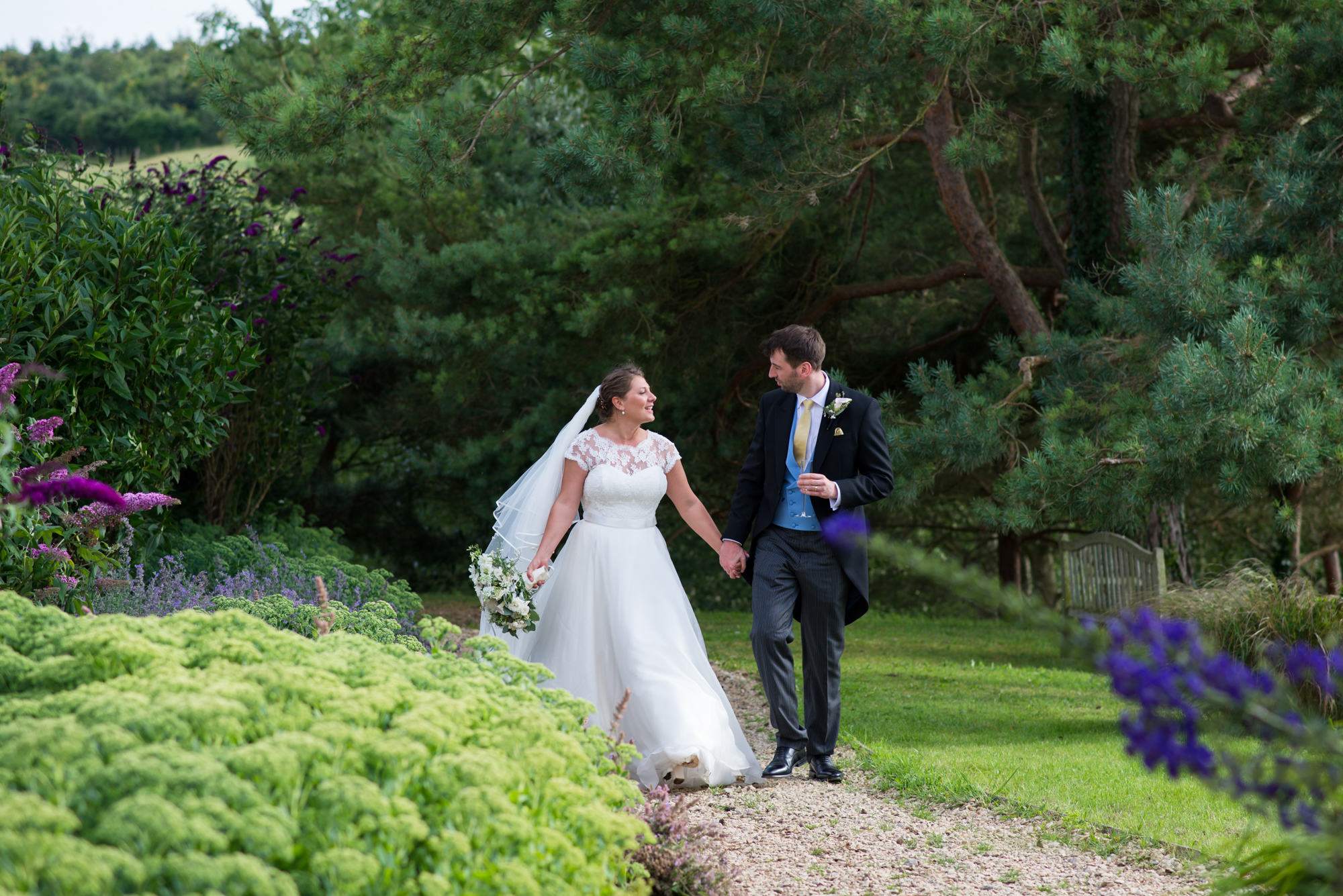 A newly married couple walking in the grounds of Whatley Manor